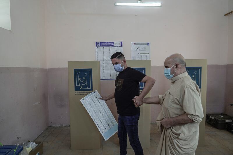 A blind man prepares to cast his vote to vote with the help of his son at a polling station in Baghdad. Photo: Haider Husseini / The National