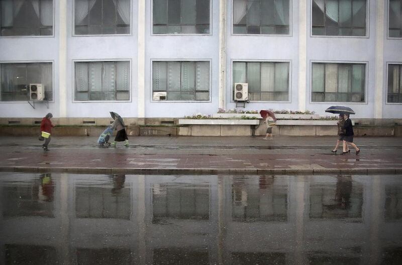 Pedestrians walk along a sidewalk on a rainy evening in Pyongyang, North Korea. Amid rising regional tensions, Pyongyang residents have been preparing for North Korea’s most important holiday: the 105th birth anniversary of Kim Il Sung, the country’s late founder and grandfather of current ruler Kim Jong Un. Wong Maye-E / AP