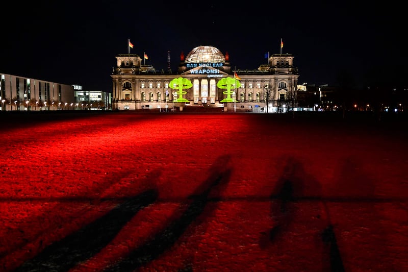 The Reichstag, the building of the lower house of the German parliament, is illuminated and an inscription reading ‘ban nuclear weapons’ has been projected on to its façade by Greenpeace activists in Berlin. AFP