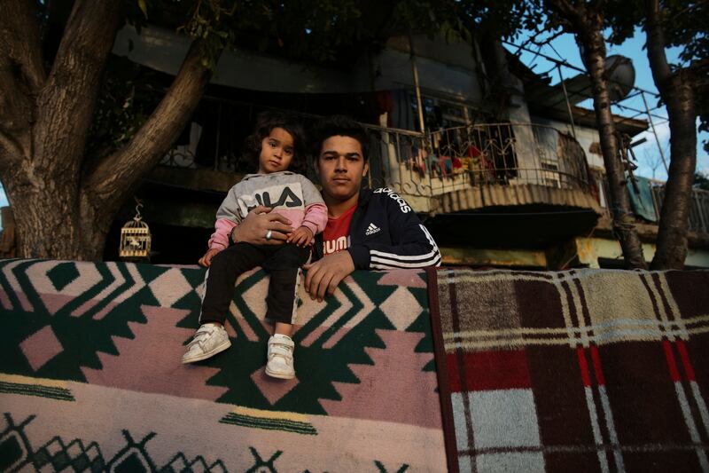 A Syrian father and daughter stand in front of their shelter in Ulus district in Ankara, Turkey. Hundreds of Syrian men and boys were detained, beaten and forcibly returned to their country by Turkish authorities over a six-month period, a leading human rights group has said. The Turkish government has in the past rejected accusations of forcibly returning refugees to Syria.  AP