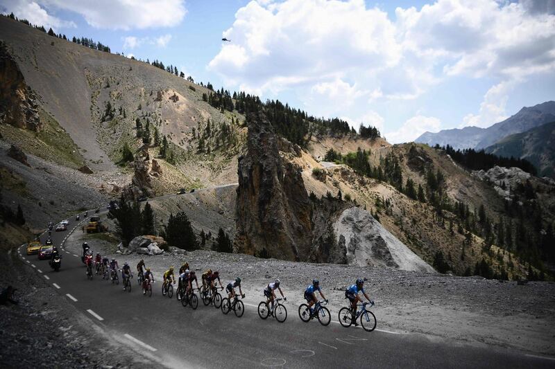 The peloton rides throught the Casse Deserte, to the Col de l'Izoard during the 18th stage between Embrun and Valloire, in Valloire, on July 25, 2019.  AFP