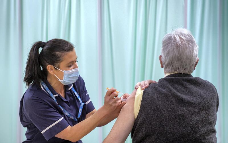 STEVENAGE, ENGLAND - JANUARY 11: A patient receives an injection of a Covid-19 vaccine at the NHS vaccine centre that has been set up at Robertson House on January 11, 2021 in Stevenage, England. The location is one of several mass vaccination centres in England to open to the public this week. The UK aims to vaccinate 15 million people by mid-February. (Photo by Joe Giddens - WPA Pool/Getty Images)