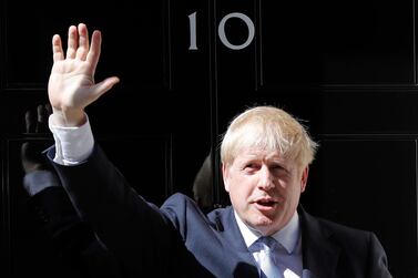 Britain's Prime Minister Boris Johnson waves from the steps outside 10 Downing Street in London. AP Photo