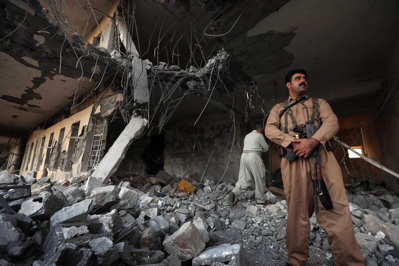 Iranian Kurdish Peshmerga members of the Iranian Kurdistan Democratic Party (KDPI) check the damage after a rocket attack inside their headquarters in Koysinjaq, 100 kilometres east of Arbil, the capital of the autonomous Kurdish region of eastern Iraq, on September8, 2018. - At least 11 members of an Iranian Kurdish rebel group were killed in a rocket attack on their headquarters in Iraqi Kurdistan today, officials said. (Photo by SAFIN HAMED / AFP)