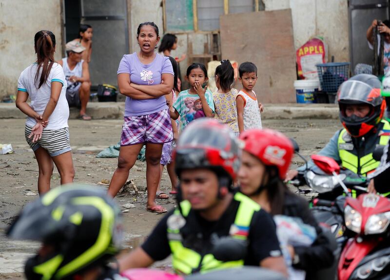 Filipino villagers wait for bags of goods from arriving motorcycle riders offering support after floods devastated the city of Marikina.  EPA