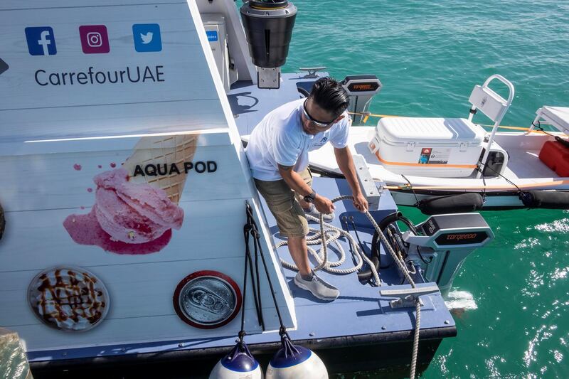 DUBAI, UNITED ARAB EMIRATES. 12 DECEMBER 2018. Trying out the new floating Carrefour mini market off the coast of Dubai. Dubai resident Marie Byrne takes her yacht out to try the new Carrefour floating shop. A Carrefour floating store cre member helps moor a yacht alongside so they can shop at the store. (Photo: Antonie Robertson/The National) Journalist: Nicke Webster. Section: National.