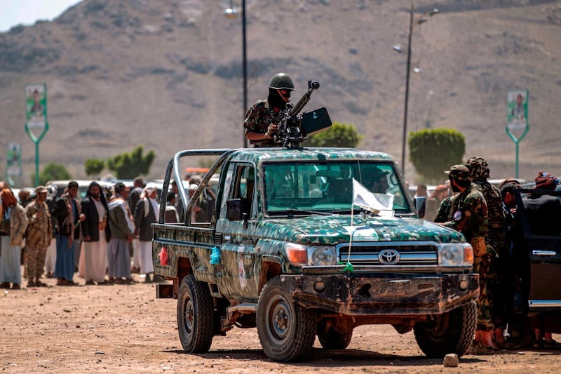 (FILES) In this file photo taken on September 21, 2019, a fighter loyal to Yemen's Huthi rebels mans a machine gun in the back of a pickup truck during a tribal meeting in the Huthi-held capital Sanaa, as tribes donate rations and funds to fighters loyal to the Huthis along the fronts. Yemen's Huthis were defiant after the United States moved to brand the Iran-backed rebels as terrorists, a last-minute move in defiance of aid groups who fear it will tip the country into famine. Unless Congress blocks the decision, the blacklisting will take effect on January 19, one day before the inauguration of President-elect Joe Biden, whose aides had hoped to mount a fresh push to end Yemen's devastating six-year-old war. / AFP / MOHAMMED HUWAIS
