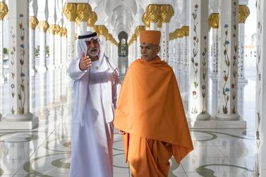 HE Sheikh Nahyan bin Mubarak Al Nahyan and His Holiness Mahant Swami Maharaj stand in the corridor of 1,096 pillars