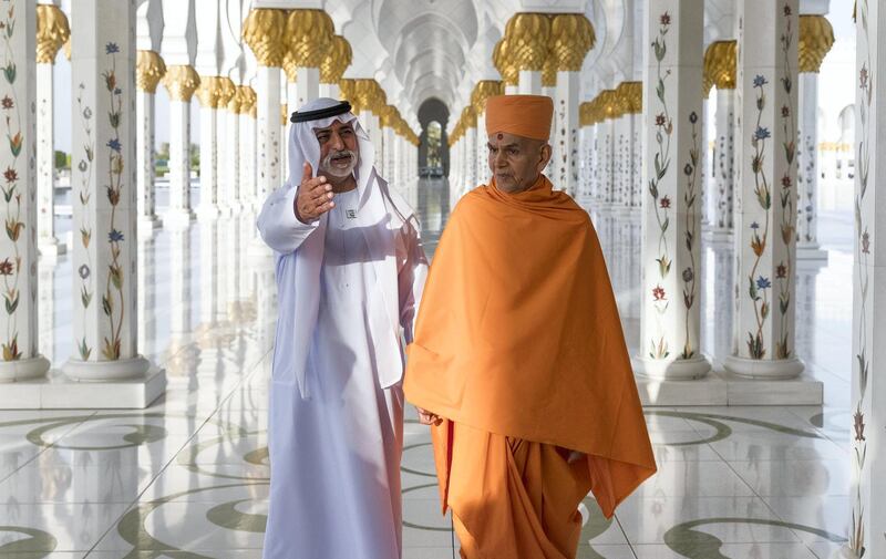 Sheikh Nahyan bin Mubarak and Mahant Swami Maharaj stand in the corridor of 1,096 pillars at the Sheikh Zayed Grand Mosque.