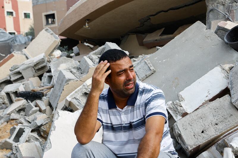 A Palestinian man reacts next to the ruins of a house destroyed in Israeli strikes in Khan Younis. Reuters