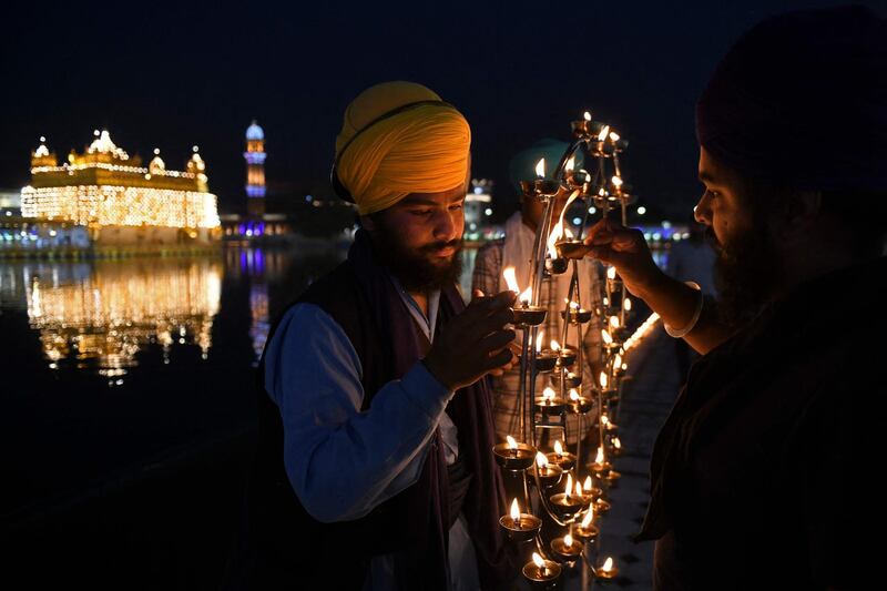 Sikh devotees light lamps on the anniversary of the birth of Guru Arjan Dev at the Golden Temple, Amritsar. AFP