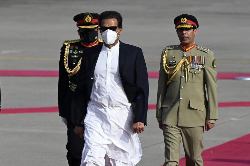 Pakistani Prime Minister Imran Khan (C) inspects a guard upon arriving for a two-day official visit to Sri Lanka, at Bandaranaike International Airport in Katunayake on February 23, 2021. (Photo by Ishara S. KODIKARA / AFP)
