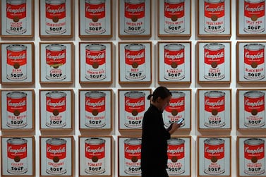 A woman walks past Andy Warhol "Campbell's Soup Cans" during a press preview on October 10, 2019, held for the expanded and re-imagined Museum of Modern Art (MOMA) ahead of the October 21 opening of its expanded campus. Developed by MoMA with architects Diller Scofidio + Renfro in collaboration with Gensler, the expansion offers a re-imagined presentation of modern and contemporary art, and adds over 40,000 square feet (3,716 square meters) of gallery space. - RESTRICTED TO EDITORIAL USE - MANDATORY MENTION OF THE ARTIST UPON PUBLICATION - TO ILLUSTRATE THE EVENT AS SPECIFIED IN THE CAPTION / AFP / TIMOTHY A. CLARY / RESTRICTED TO EDITORIAL USE - MANDATORY MENTION OF THE ARTIST UPON PUBLICATION - TO ILLUSTRATE THE EVENT AS SPECIFIED IN THE CAPTION