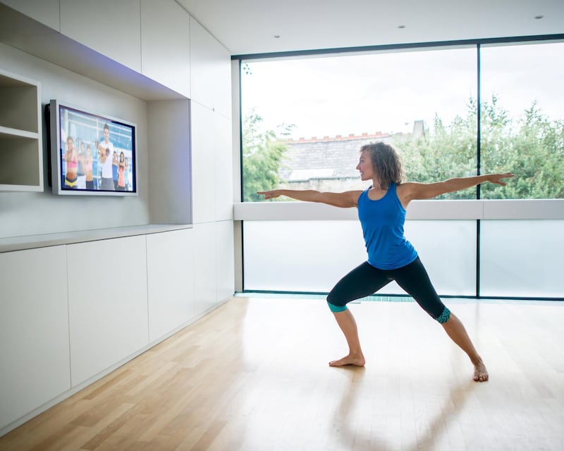 Healthy woman exercising at home watching a Pilates DVD and following the routine