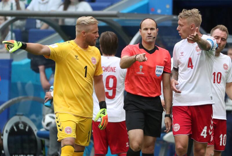 Denmark's Kasper Schmeichel and Simon Kjaer protest to referee Antonio Mateu Lahoz after he awarded a penalty to Australia following a VAR referral. Pilar Olivares / Reuters