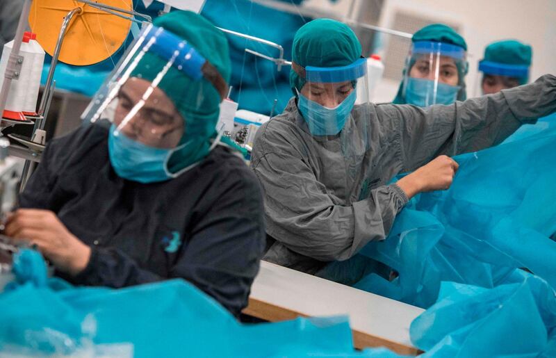 Workers in a factory produce gowns and other protective gear to be used by paramedics and first responders, in the city of Berrechid in Morocco. AFP