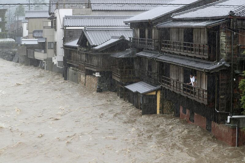 Men watch the swollen Isuzu River due to heavy rain caused by Typhoon Hagibis in Ise, central Japan. Reuters