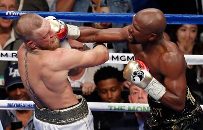 FILE - In this Aug. 26, 2017, file photo, Floyd Mayweather Jr. hits Conor McGregor in a super welterweight boxing match in Las Vegas. The AP reported on Sept. 1, 2017, that a story claiming a boxing promoter connected to the fight was found shot dead in Washington, D.C. is a hoax. (AP Photo/Eric Jamison, File)