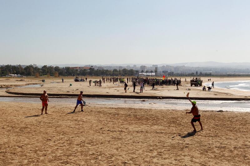 Bat and ball games at Tyre in southern Lebanon as volunteers clean a beach after an oil spill. Reuters