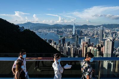 (FILES) In this file photo taken on July 28, 2020, visitors walk along a viewing platform on Victoria Peak in Hong Kong. Hong Kong and Singapore announced on April 26, 2021 plans to resurrect their scrapped coronavirus travel bubble with dedicated flights between the two cities starting on May 26. / AFP / Afp / ANTHONY WALLACE
