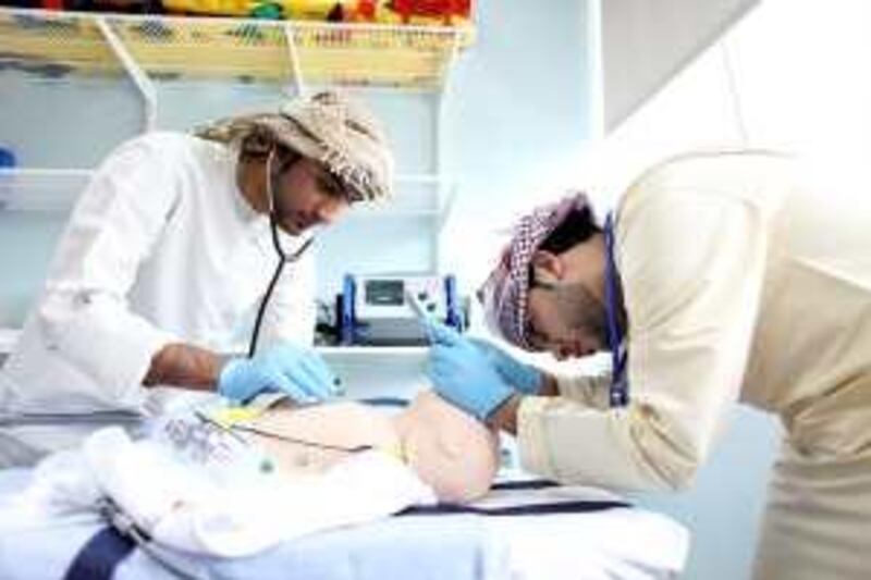 April 25, 2010 / Abu Dhabi / (Rich-Joseph Facun / The National) Ahmed al Hammadi (CQ), left and Abdulla al Zhami (CQ), right, both paramedic students at Abu Dhabi Men's College work through a life saving procedure on a faux baby Sunday, April 25, 2010 in Abu Dhabi. 