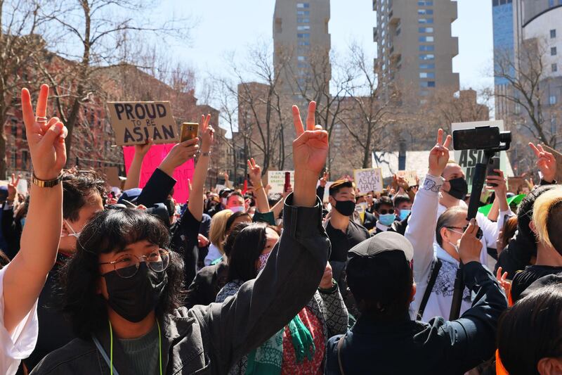 People hold up peace signs as rapper Jin performs at a rally against hate in Columbus Park on March 21, 2021 in the Chinatown neighbourhood of Manhattan in New York. A rally for solidarity was organised in response to a rise in hate crimes against the Asian-American community since the start of the coronavirus pandemic in 2020. AFP