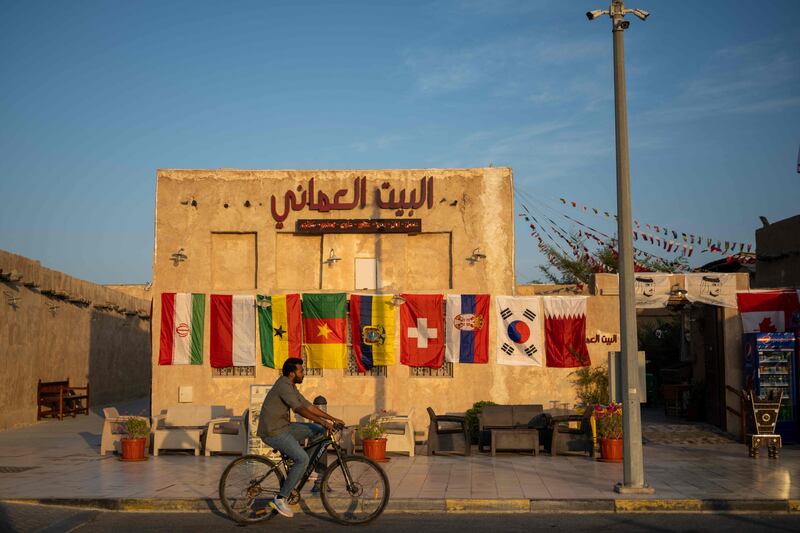 A man rides a bicycle past a restaurant adorned with FIFA World Cup playing countries’ flags in a market area in Doha ahead of the Qatar 2022 FIFA World Cup football tournament. AFP