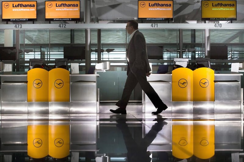 A traveller walks past empty service counters at the airport in Munich. Peter Kneffel / EPA