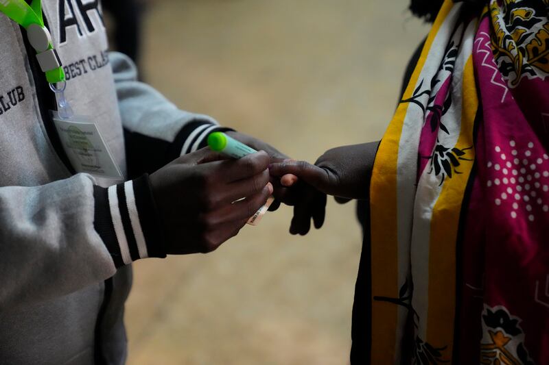 An election official marks the hand of a voter at the Kibera primary school in Nairobi. AP