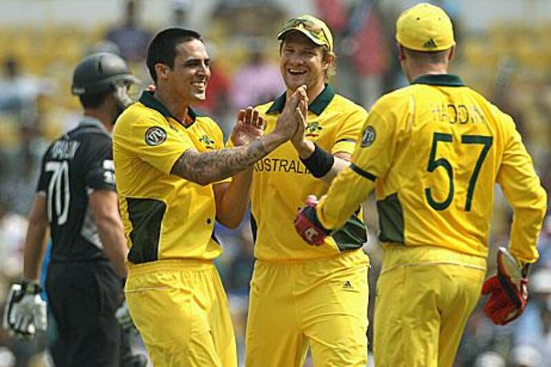 Mitchell Johnson celebrates with his teammates  after the wicket of James Franklin, background, in Nagpur.