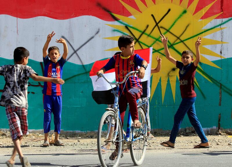 A boy drives a bicycle with an Iraqi flag in Dibis area on the outskirts of Kirkuk, Iraq. Alaa Al-Marjani / Reuters