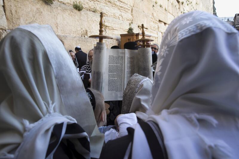 Jewish worshippers reads from the Torah scroll during a special priestly blessing for Passover at the Western Wall, Judaism's holiest prayer site, in Jerusalem's Old City April 6, 2015. REUTERS/Ronen Zvulun  - GF10000050823