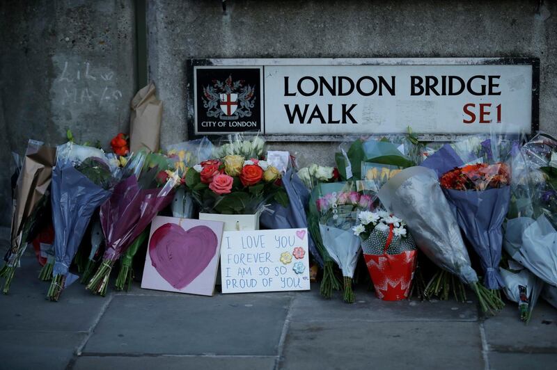 FILE - In this Monday, Dec. 2, 2019 file photo, tributes are placed by the southern end of London Bridge, three days after a man stabbed two people to death and injured three others before being shot dead by police, in London. A mysterious figure who used a rare narwhal tusk to help subdue a knife-wielding extremist on London Bridge last month has been identified as a civil servant in Britain's Justice Ministry. Darryn Frost ended his silence Saturday, Dec. 21 telling Britain's Press Association that he and others reacted instinctively when Usman Khan started stabbing people at a prison rehabilitation program at a hall next to the bridge on Nov. 29.(AP Photo/Matt Dunham, file)