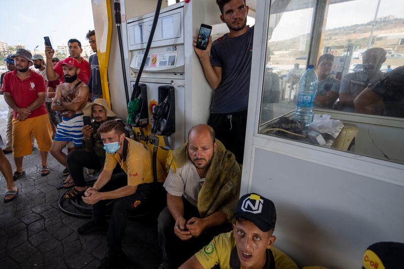 Worshippers listen as cleric Ali Al Hussein delivers a sermon during Friday prayers at a fuel station to protest against the severe shortages. AP