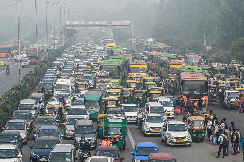 Commuters make their way along a busy road in New Delhi. AFP
