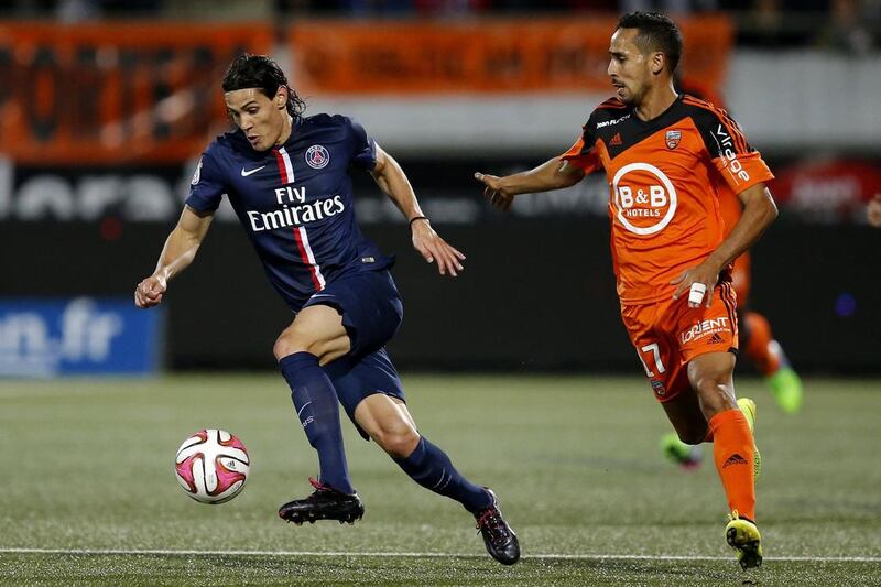 Paris St Germain's Edinson Cavani, left, fights for the ball with Lorient's Walid Mesloub during their French Ligue 1 match at the Moustoir stadium in Lorient November 1, 2014.  Stephane Mahe / Reuters