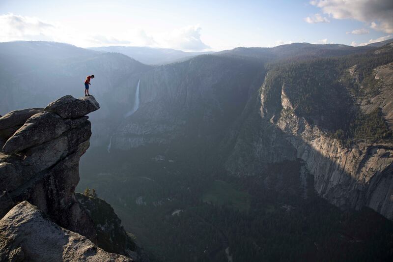 Alex Honnold peers over the edge of Glacier Point in Yosemite National Park. He had just climbed 2000 feet up from the valley floor. (National Geographic/Jimmy Chin)