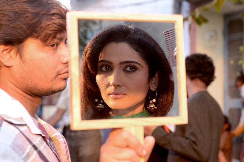 Indian Bollywood actress Gauri Singh is reflected in a mirror as she adjusts her makeup during filming on the set of the Punjabi film ìBolo Tara Rara ì in Amritsar. NARINDER NANU / AFP