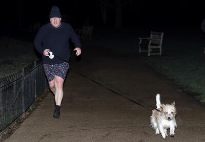 UK Prime Minister Boris Johnson jogs with his dog Dilyn through St James's Park in London on Monday. He is facing a tough week ahead as an inquiry into party allegations at his official residence continues. Reuters