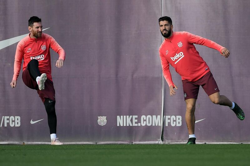 Lionel Messi, left, and Luis Suarez warm-up during Barcelona's training session. AFP