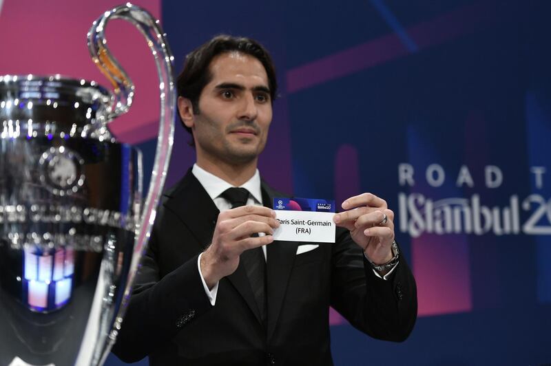 UEFA Champions League's ambassador Hamit Altintop holds the slip of Paris Saint-Germain during the UEFA Champions League football cup round of 16 draw ceremony on December 16, 2019 in Nyon.  / AFP / Fabrice COFFRINI
