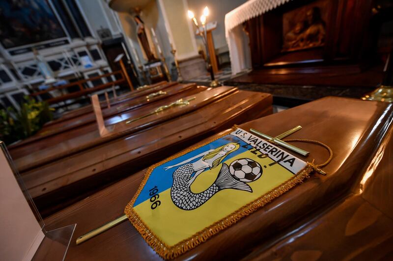 Coffins, one of them with the pennant of the local soccer team, wait to be transported to cemetery, in the church of Serina, near Bergamo, Northern Italy.  AP