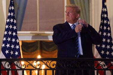 US President Donald Trump takes off his face mask at the White House. Global shares plummeted after President Trump scrapped negotiations over Covid-19 economic relief funding until after the presidential election on November 3. AFP