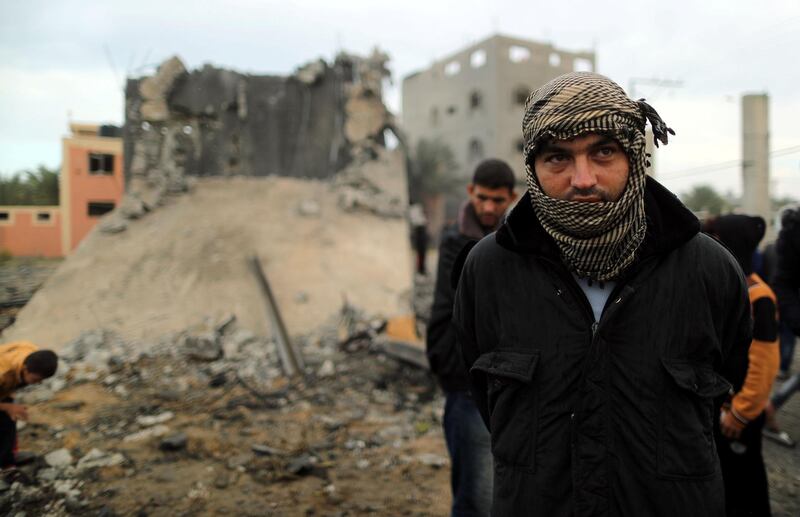 A Palestinian man looks on as he stands in front of a building that was destroyed by an Israeli air strike, in Khan Younis. Reuters