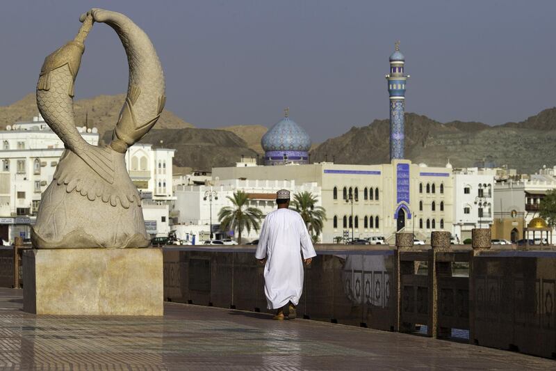 An Omani man walks along the Mutrah Corniche seafront lined with 19th Century merchants houses in the old city of Muscat, Oman, on Monday, May 7, 2018. Being the Switzerland of the Gulf served the country well over the decades, helping the sultanate survive, thrive and make it a key conduit for trade and diplomacy in the turbulent Middle East. Photographer: Christopher Pike/Bloomberg