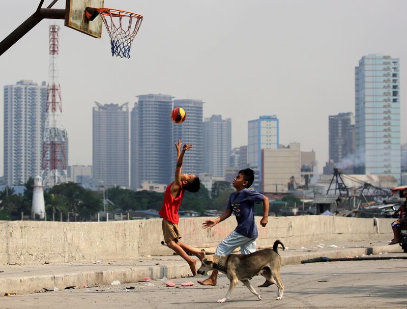 Filipino children play basketball at a slum area in Manila, Philippines. EPA