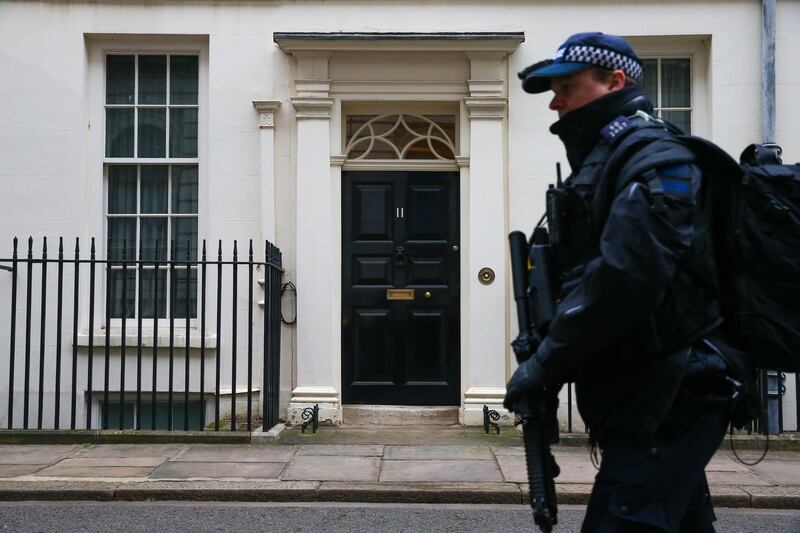 An armed police officer passes number 11 Downing Street. Bloomberg