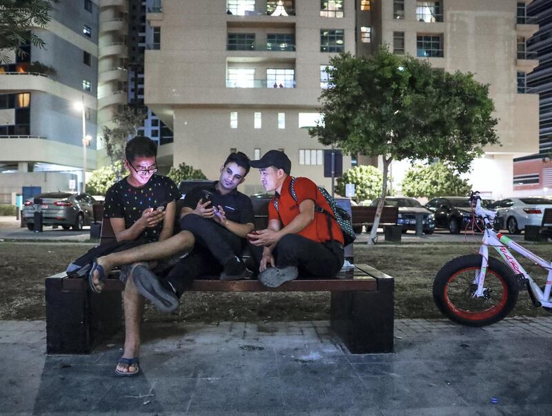 Abu Dhabi, U.A.E., November 5, 2018.   Neighbourhood: "Starbucks" - It goes by many names. Starbucks. New York. -- Local bistro workers taking a break after work at the park.  (L-R) Bishwo Basnet-23, Subash Bista-26 and Bir Bahadur Rai-26.
Victor Besa / The National
Section:  NA
Reporter:  Anna Zacharias