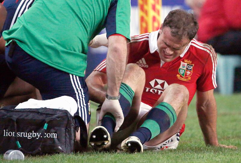 British and Irish Lions'Jamie Roberts (R) sits on the sideline being assisted by team trainers after being injured during the rugby union game against the New South Wales Waratahs at the Sydney Football Stadium June 15, 2013.  REUTERS/David Gray  (AUSTRALIA - Tags: SPORT RUGBY)