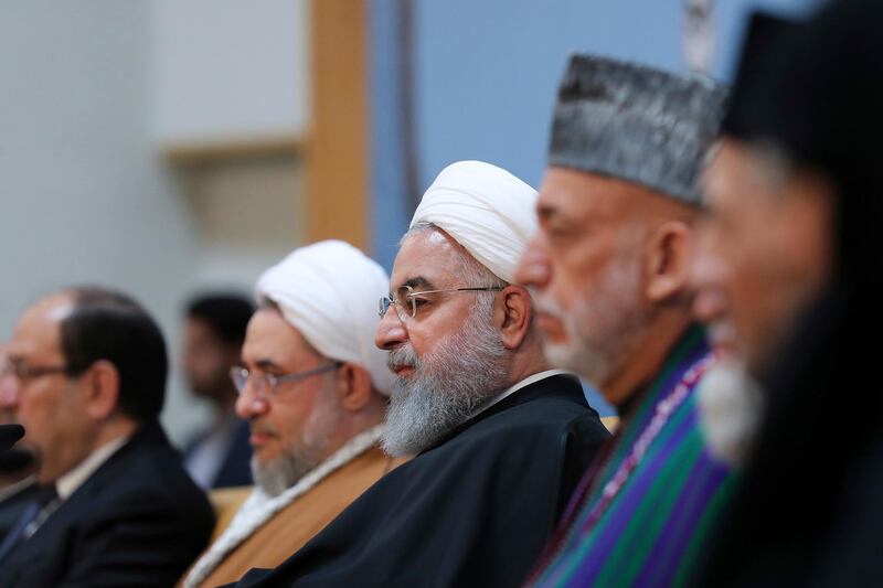 In this photo released by official website of the office of the Iranian Presidency, President Hassan Rouhani, center, attends an annual Islamic Unity Conference in Tehran, Iran, Saturday, Nov. 24, 2018. Rouhani has called Israel a "cancerous tumor" established by Western countries to advance their interests in the Middle East. (Iranian Presidency Office via AP)